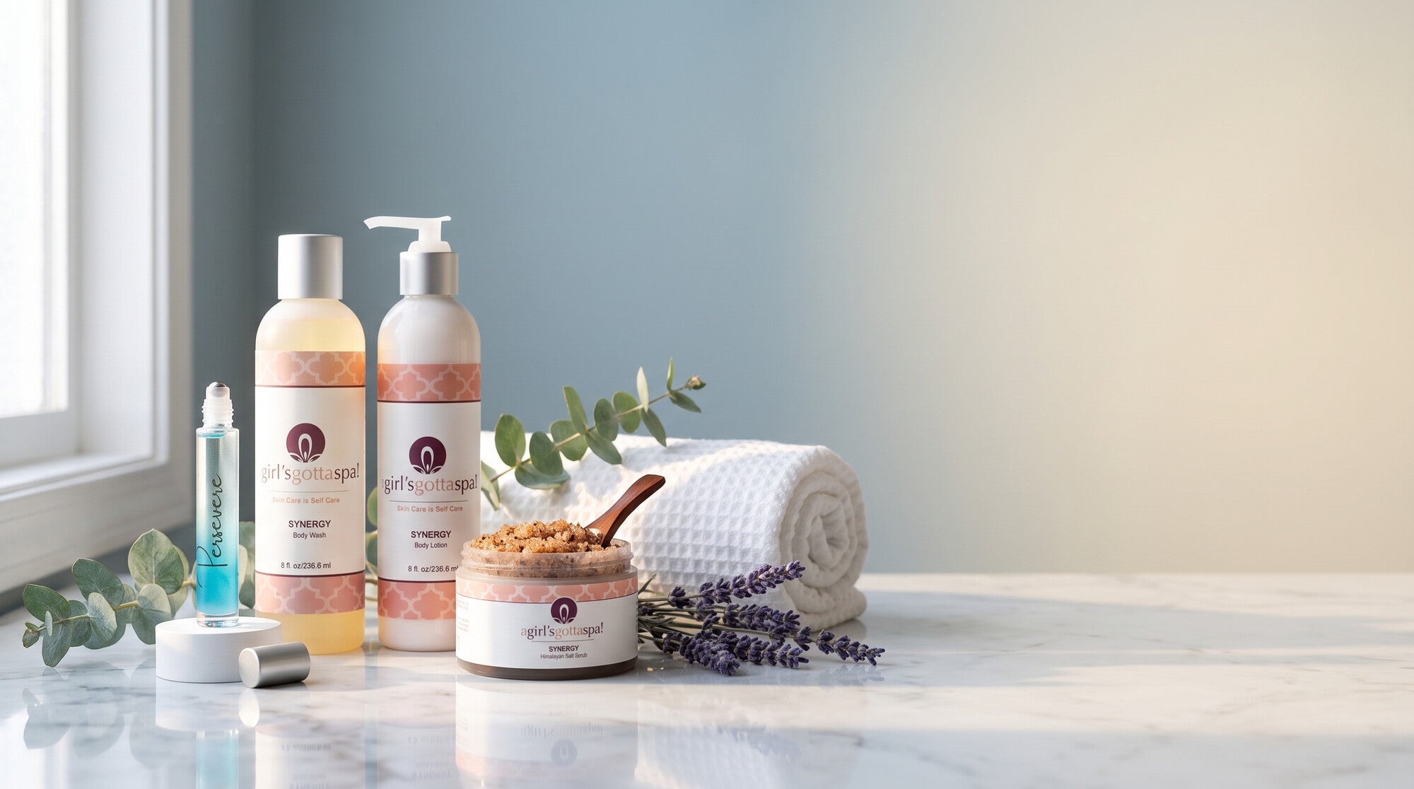 A Girl's Gotta Spa Synergy Body Wash, Body Lotion and Himalayan Salt Scrub on a marble spa vanity